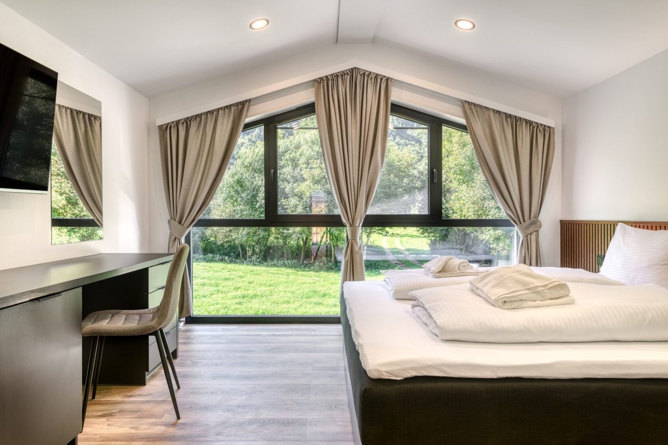Helles Schlafzimmer bei bsundrix mit großem Fenster ins Grüne